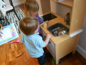children play in toy kitchen