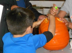 children carving jack-o-lantern