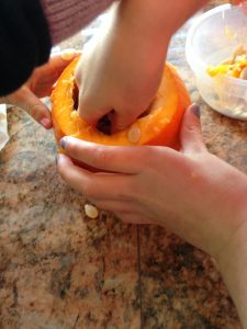scooping out a pumpkin